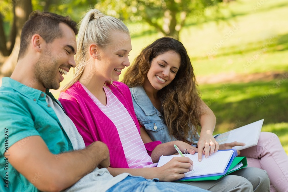 Happy college friends sitting on campus bench Happy college friends sitting on campus bench