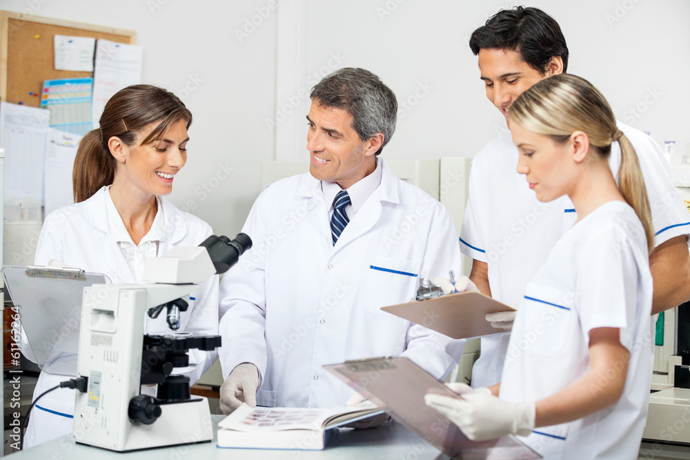 Researcher With Students Taking Notes In Lab Researcher With Students Taking Notes In Lab