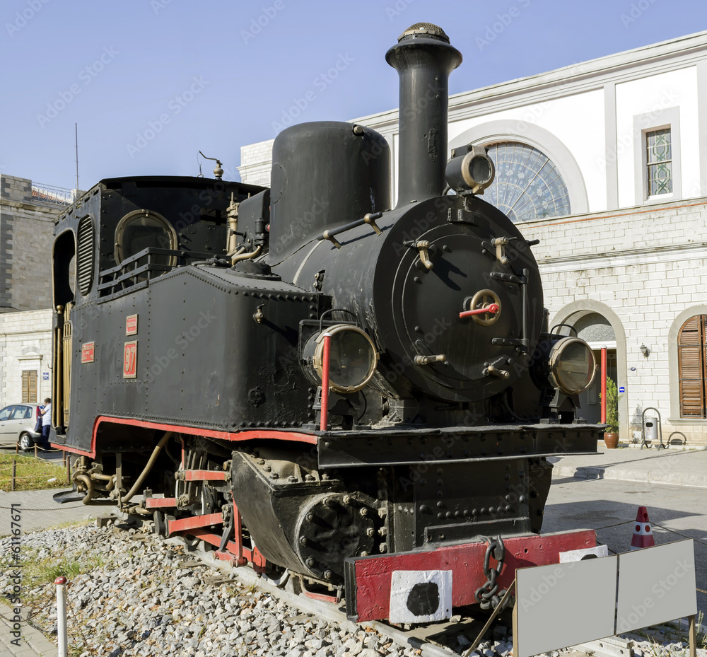 Naklejka premium Vintage steam train alongside platform at railway station
