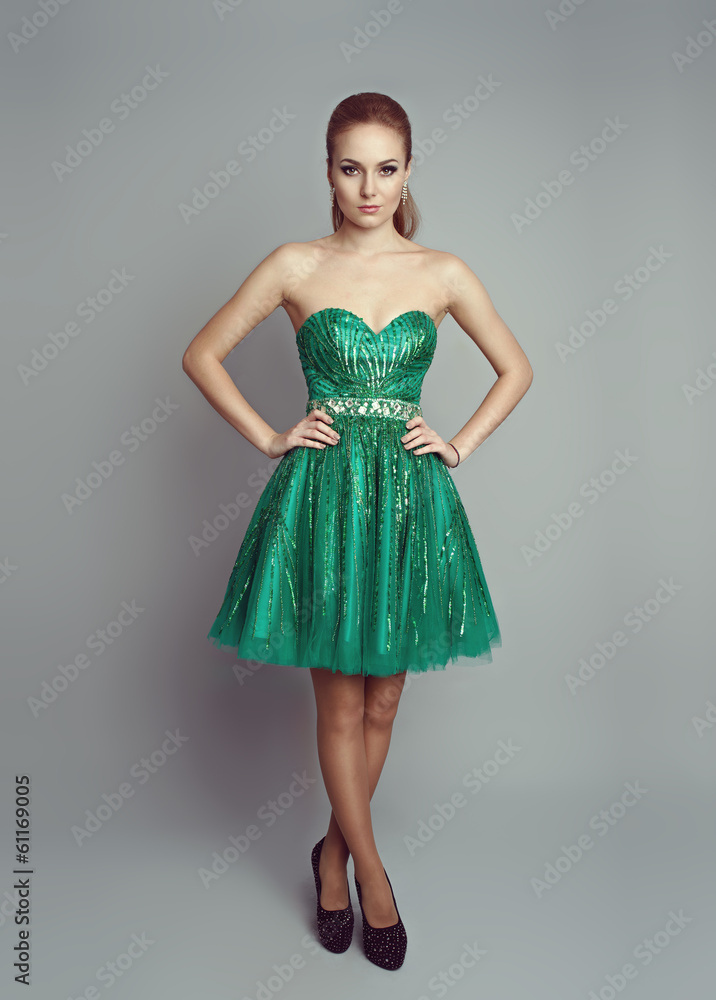 Naklejka premium Pretty woman in luxury green dress wearing high heels