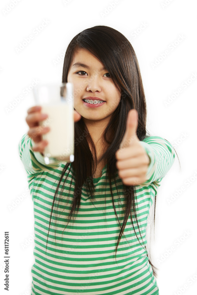 Mädchen hält Milchglas in Hand, andere Hand Daumen-Hoch-Zeichen Mädchen hält Milchglas in Hand, andere Hand Daumen-Hoch-Zeichen
