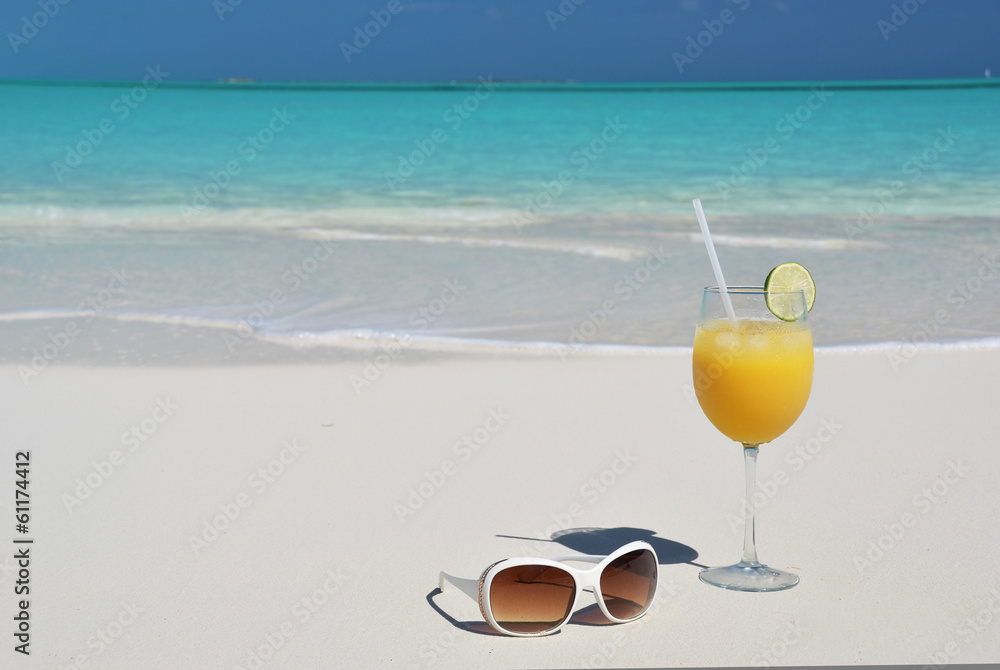 Orange juice and sunglasses on the beach. Exuma, Bahamas Orange juice and sunglasses on the beach. Exuma, Bahamas