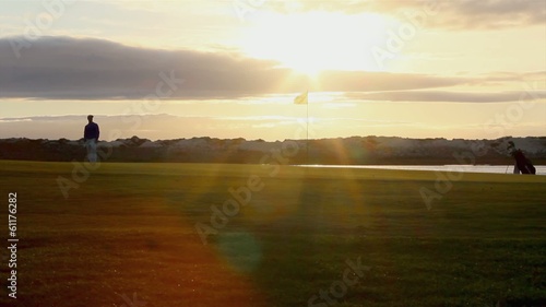 Golfer silhouette playing at twilight in Algarve