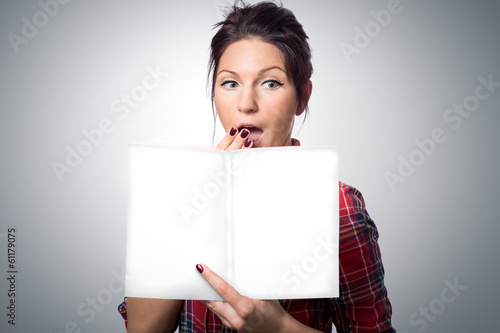 Surprised  young woman holding magazine with empty cover photo