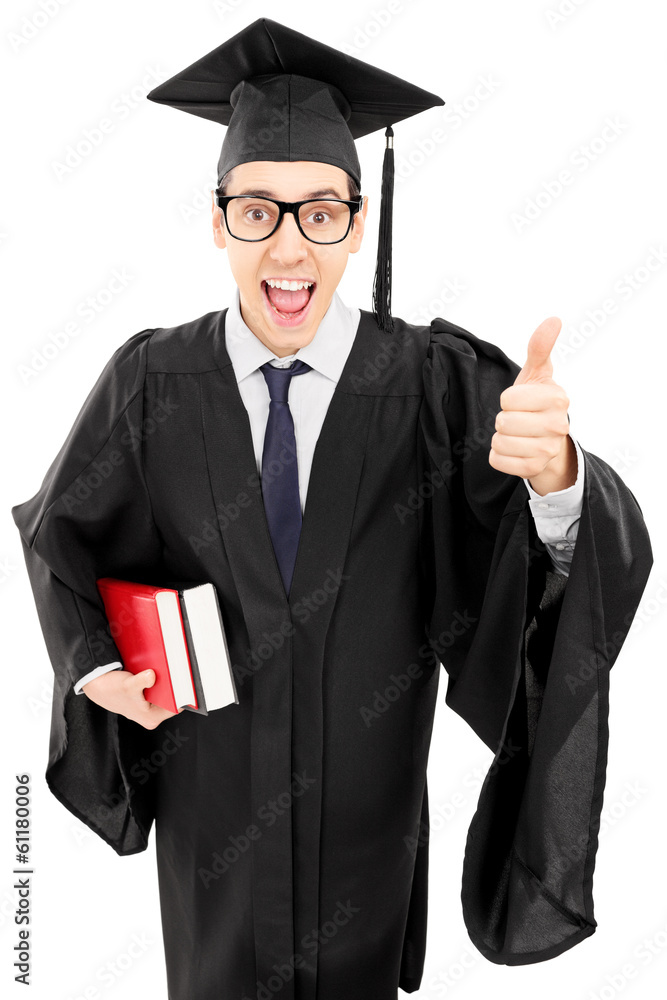 Young man in gown holding books and giving thumb up Young man in gown holding books and giving thumb up
