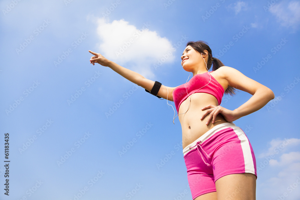 Asian smiling sporty woman watching and pointing far away Asian smiling sporty woman watching and pointing far away