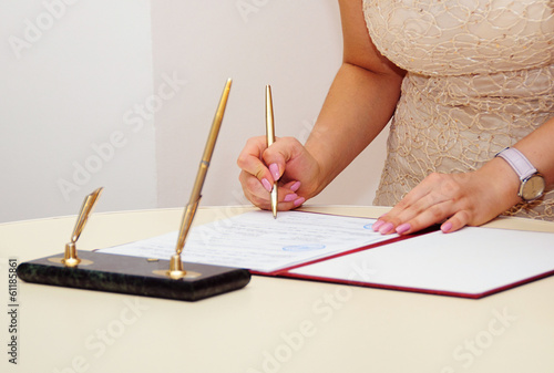 Bride signing marriage license or wedding contract