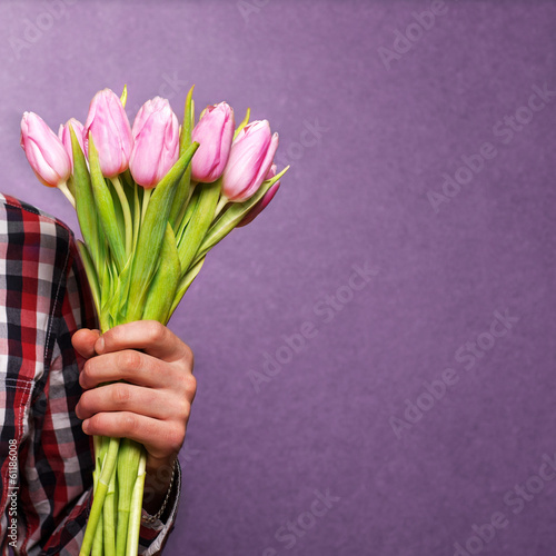 Fototapeta Naklejka Na Ścianę i Meble -  man clothing hipster holding a bouquet of flowers