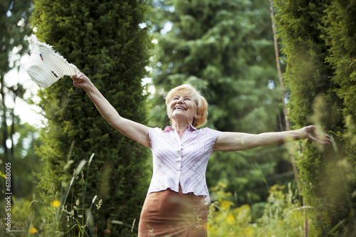 Freedom. Old Lady with Hut smiling in The Garden. Lifestyle