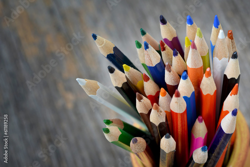 Colorful pencils in ceramic boot on wood background photo