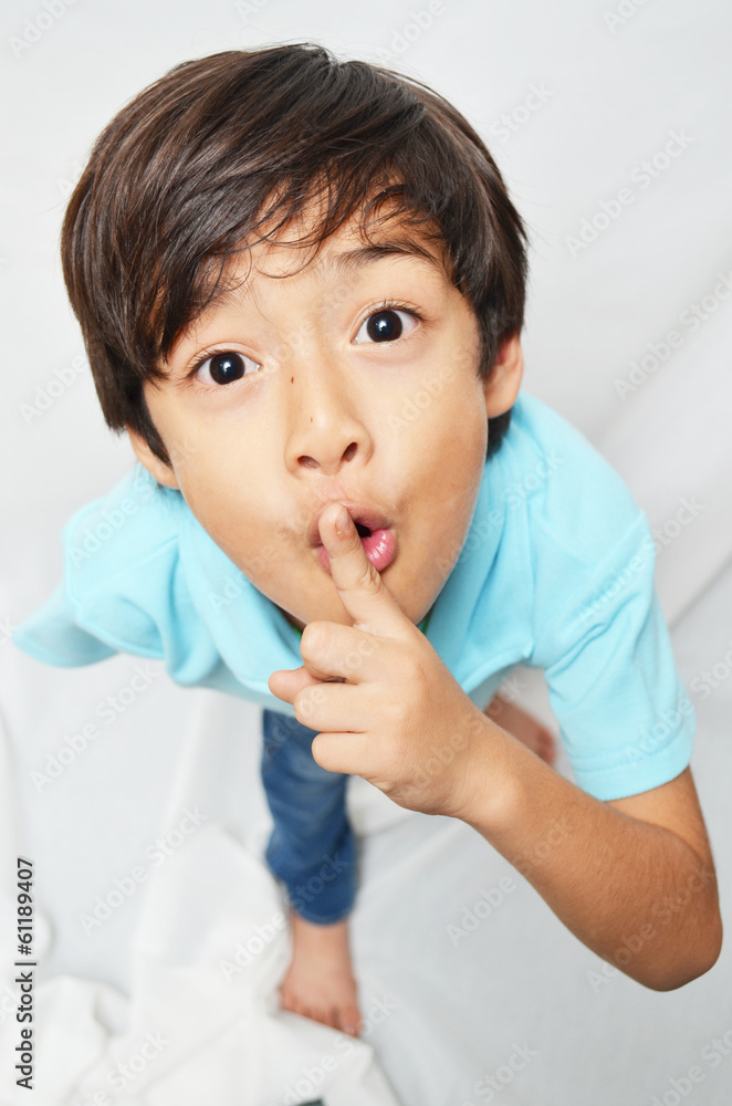 Little 6 years boy mix portrait finger on mouth Little 6 years boy mix portrait finger on mouth