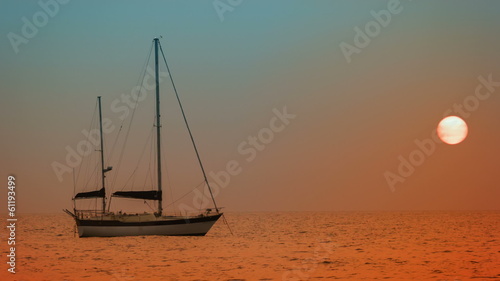 Yacht at anchor in the bay. Sunset on the tropical ocean