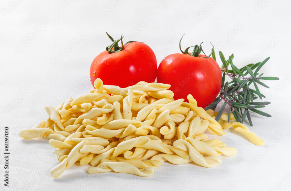 Strozzapreti with tomatoes on white background