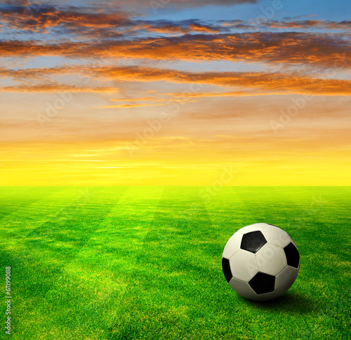 soccer ball on grass in the sunset