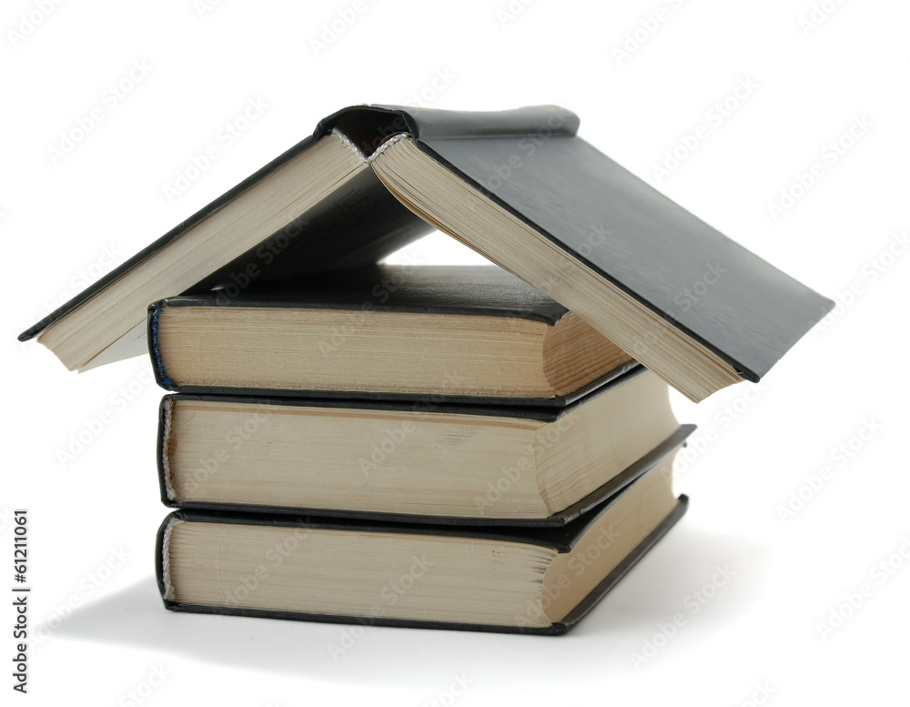 House made with books piled on white background. House made with books piled on white background.