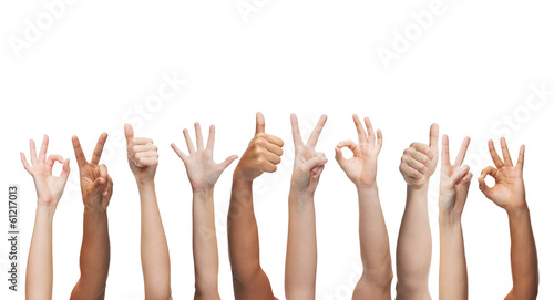 human hands showing thumbs up, ok and peace signs