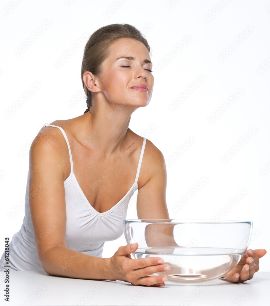 Relaxed young woman with glass bowl with water Relaxed young woman with glass bowl with water