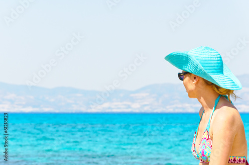 Beautiful young woman in swimsuit, relaxing on a sunny beach