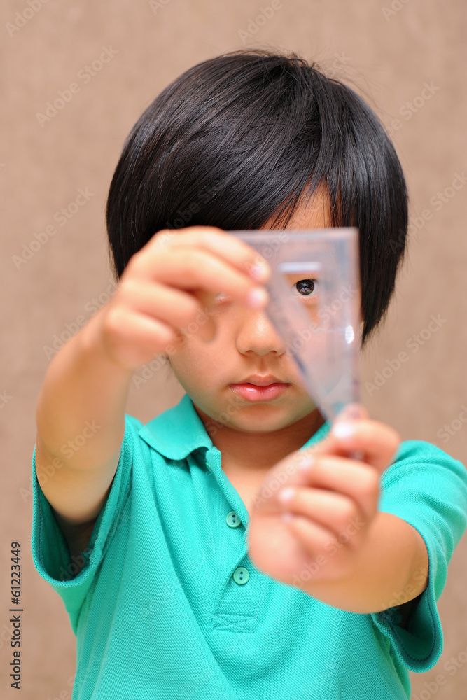 Asian schoolboy holding a set square (triangle) Asian schoolboy holding a set square (triangle)