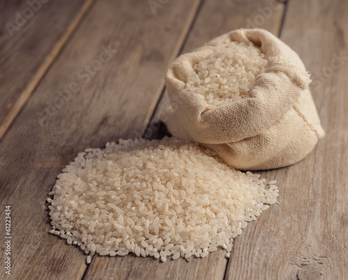 White rice in a sack on a wooden table