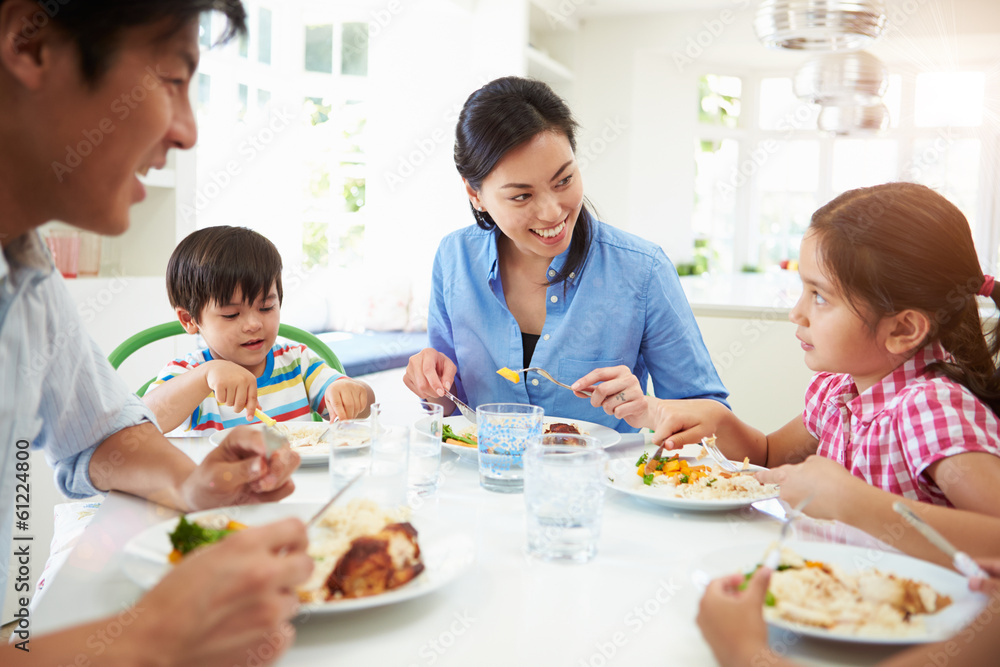Asian Family Sitting At Table Eating Meal Together Asian Family Sitting At Table Eating Meal Together