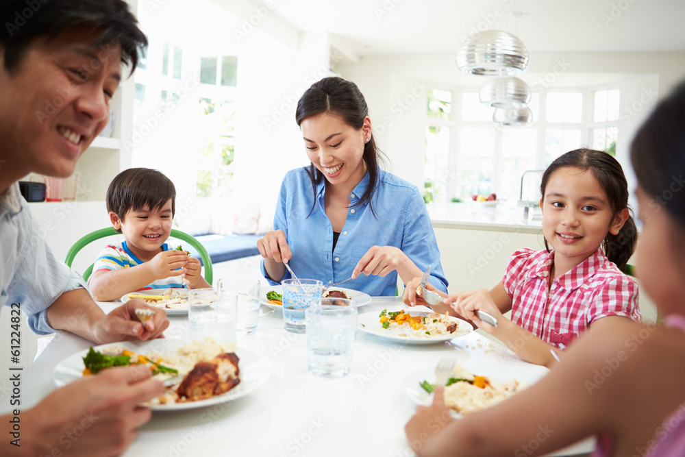 Asian Family Sitting At Table Eating Meal Together