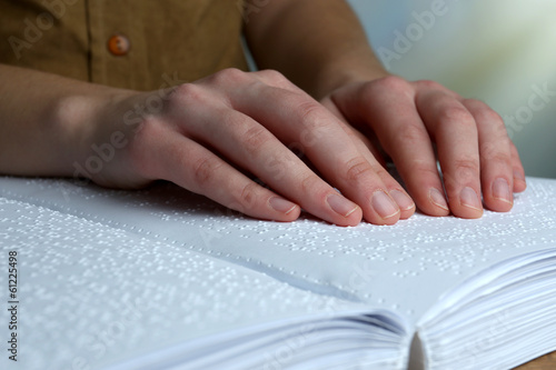 Blind woman read book written in Braille