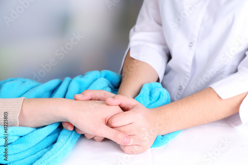Medical doctor holding hand of patient, on light background © Africa Studio