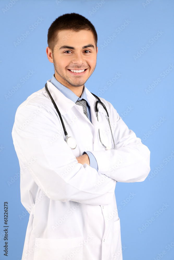 Male Doctor standing with folder, on blue background Male Doctor standing with folder, on blue background
