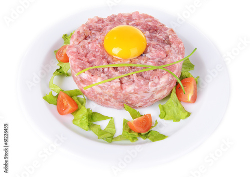 Delicious steak tartare with yolk on plate isolated on white