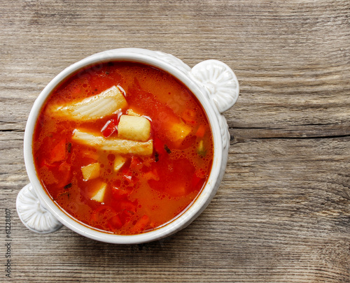 Bowl of tomato soup on wooden table