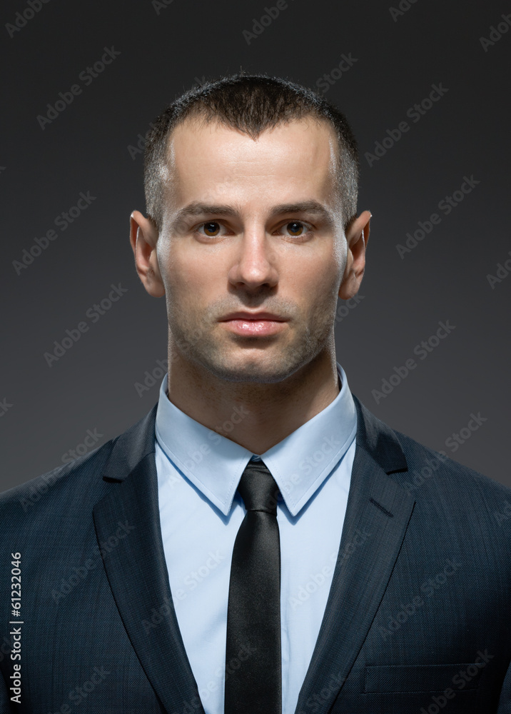 Front view of self-confident male in dark suit with black tie Front view of self-confident male in dark suit with black tie