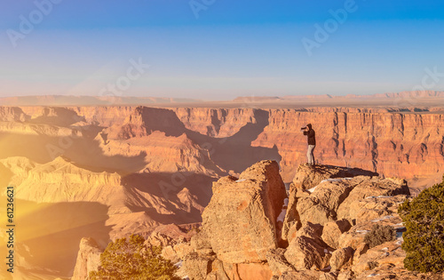 Adventurous man taking a photo at Grand Canyon before sunset