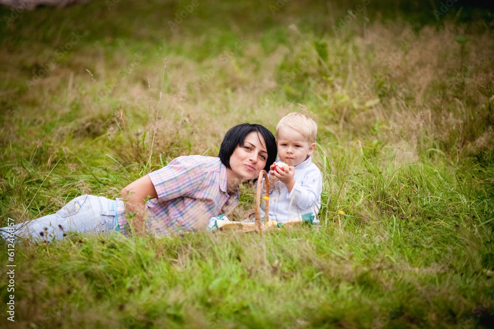 Fototapeta premium Mom and son eating fruit with wicker baskets