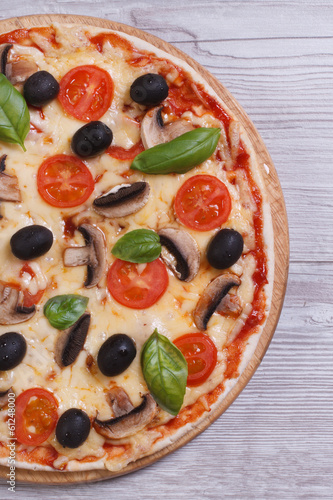 half mushroom pizza with olives, tomatoes and basil