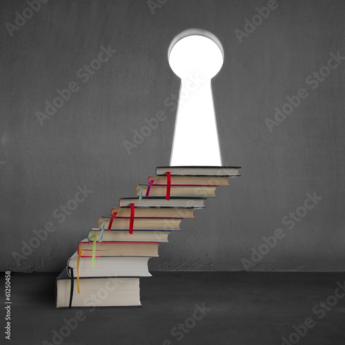 Stack of books with key shape door on concrete wall