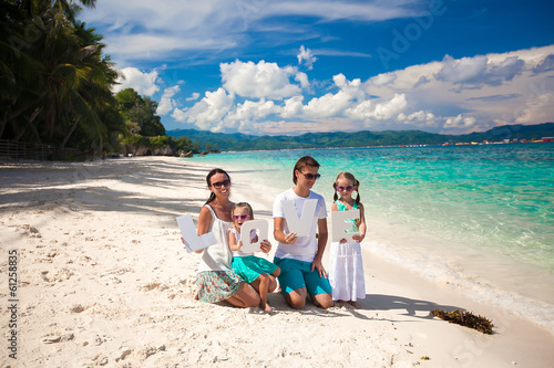 Young happy family of four on tropical vacation with word LOVE © travnikovstudio