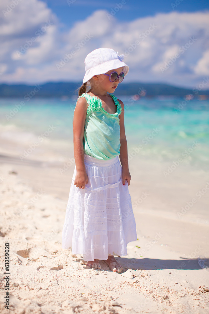 Adorable little girl walking on tropical white beach
