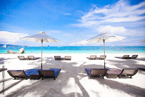 White umbrella and chairs at beach background the blue sea