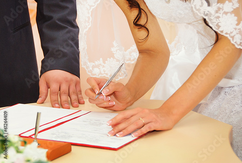 Bride signing marriage license or wedding contract