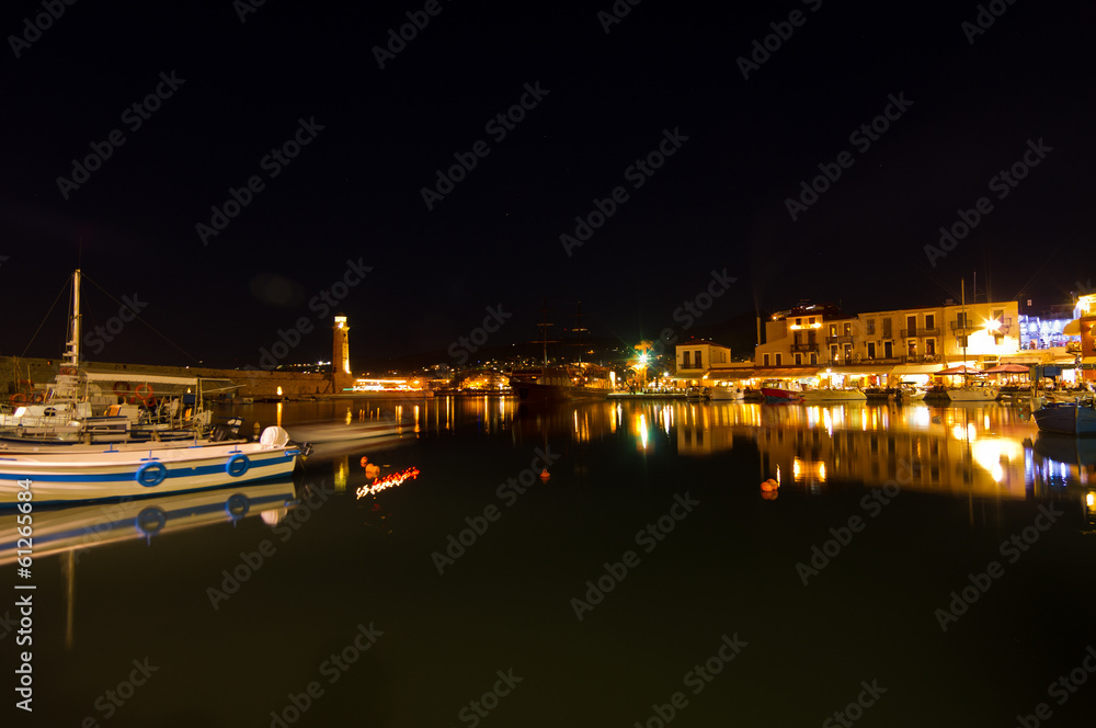 Ships at the old venetian harbor with lighthouse at night, Crete