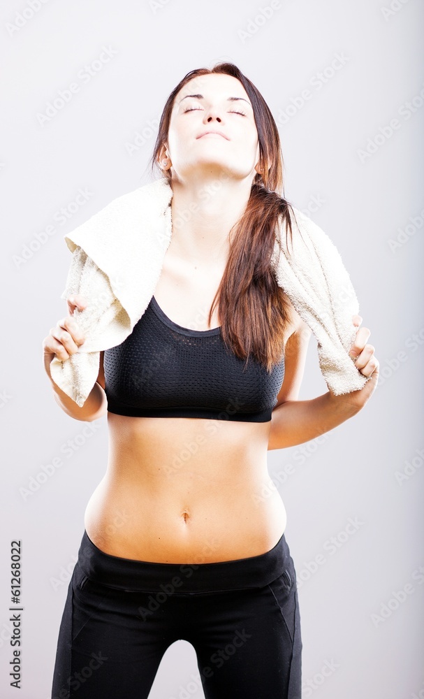 Exhausted woman after training wiping with towel Exhausted woman after training wiping with towel