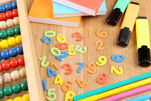 Colorful numbers, abacus, books and markers on wooden