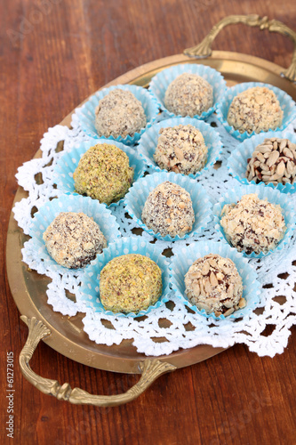 Set of chocolate candies, on tray, on wooden background