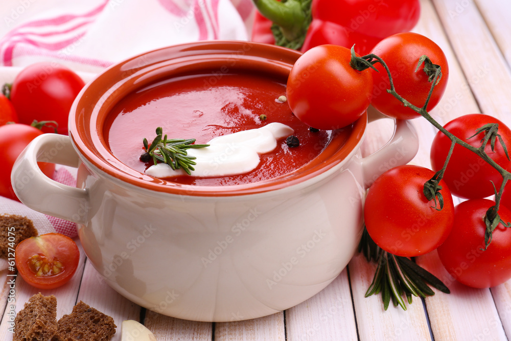 Tasty tomato soup and vegetables on wooden table Tasty tomato soup and vegetables on wooden table