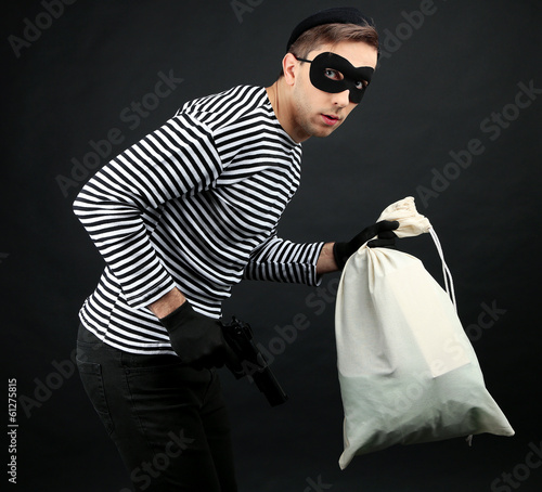 Thief with bag isolated on black photo