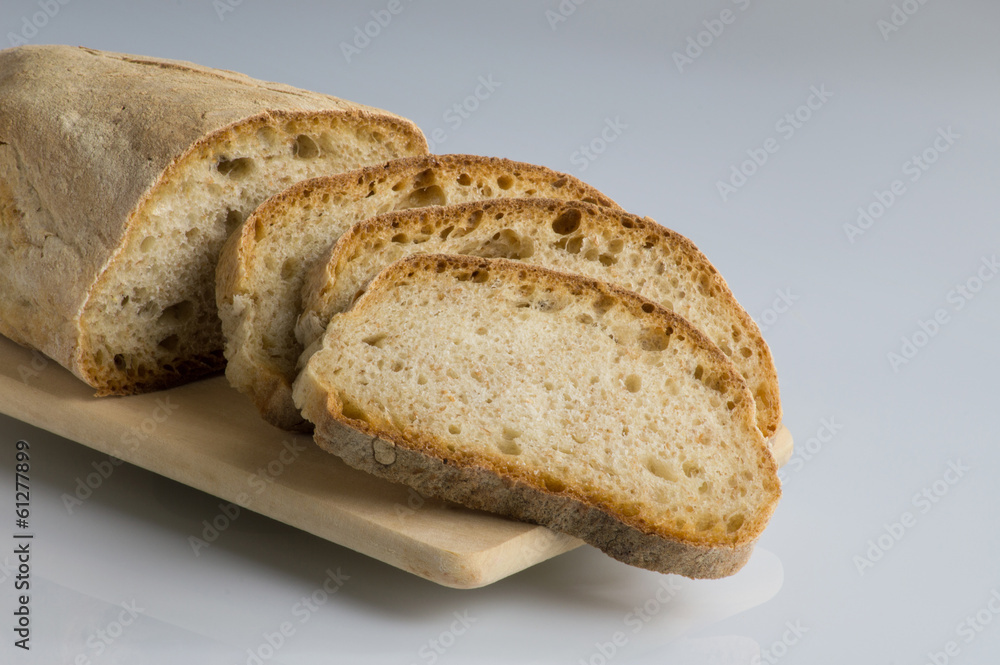 Fresh bread sliced ​​on cutting board in plain sight