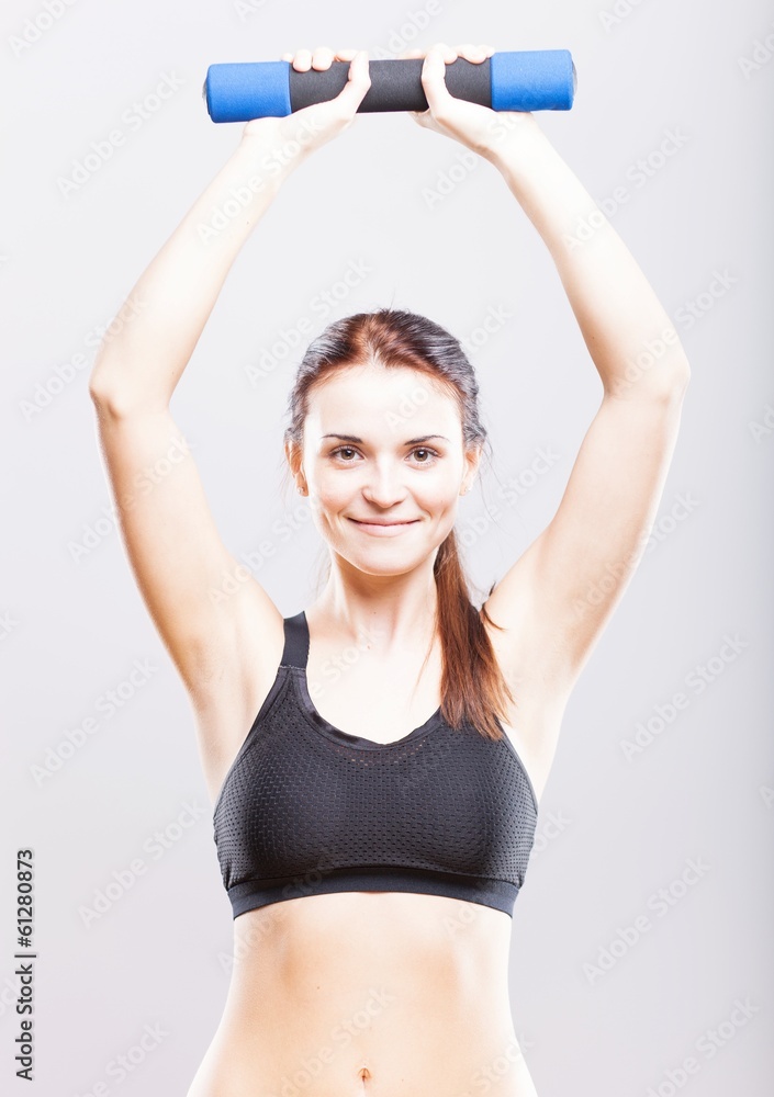 Fit woman during exercise with dumbbells Fit woman during exercise with dumbbells