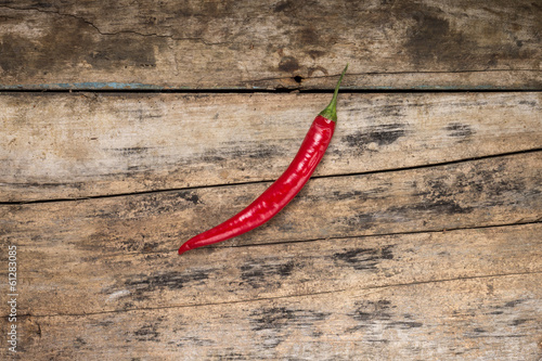One Red Chilli Pepper on Grunge Wood board