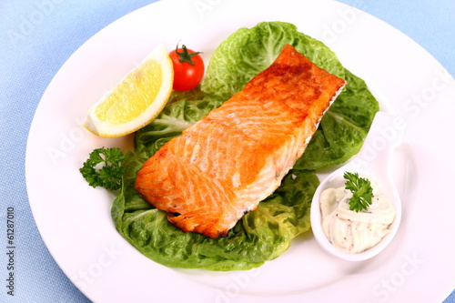 Grilled salmon fillet with salad, tomato and sauce